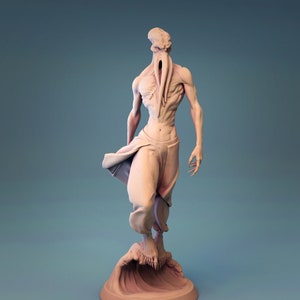 Puede incluir: Una figurita beige de una figura humanoide con una cabeza y tentáculos de pulpo. La figura está de pie sobre una base de ola.