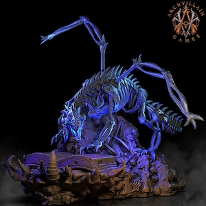 May include: A skeletal dragon with glowing blue wings perched atop a pile of skulls and a large, open book. The dragon's head is lowered as if reading the book. The base of the sculpture is made of a dark, textured material.
