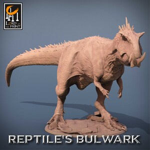 Puede incluir: Una miniatura detallada de un dinosaurio, impresa en 3D y pintada en un color marrón claro. El dinosaurio tiene una cresta espinosa en la cabeza y un cuerno en el hocico. La miniatura está de pie sobre una base y está etiquetada como "Reptile's Bulwark".