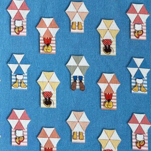 Op de afbeelding: Een blauwe en witte stof met een herhalend patroon van cartoonfiguren die ontspannen onder parasols op het strand. De personages zijn Mickey Mouse, Minnie Mouse, Donald Duck en Goofy.