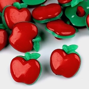 May include: Red apple-shaped buttons with green stems and leaves. The buttons are shiny and have a glossy finish.
