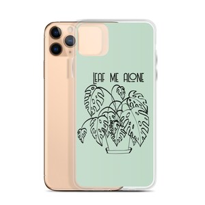 Op de afbeelding: Een lichtgroene telefoonhoes met een zwarte lijntekening van een plant in een pot en de tekst "LEAF ME ALONE".