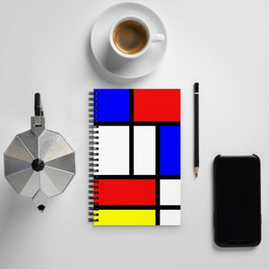 May include: A spiral bound notebook with a colourful geometric design inspired by Piet Mondrian's art. The cover features squares in red, blue, yellow, and white.