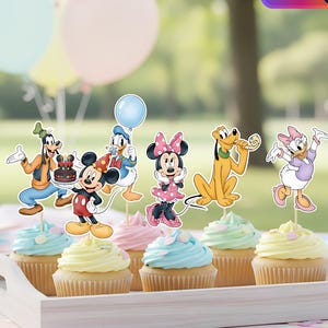 Könnte beinhalten: Tablett mit Cupcakes, verziert mit Disney-Figuren. Die Cupcakes haben pastellfarbenes Frosting, und die Dekorationen zeigen Micky Maus, Minnie Maus, Donald Duck, Goofy, Pluto und Daisy Duck. Ballons im Hintergrund.
