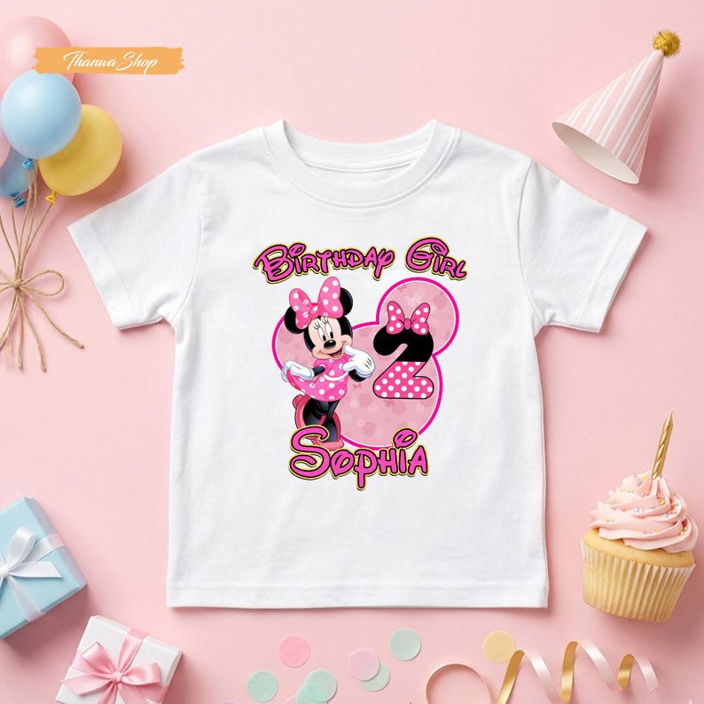 May include: A white short-sleeve t-shirt featuring a graphic of Minnie Mouse, a large pink number two, and the text "Birthday Girl Sophia" in pink and yellow. The design includes polka dot patterns on the character's dress and the number.