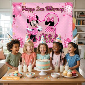 May include: A pink banner with "Happy 2nd Birthday" and Minnie Mouse graphics hangs behind five children. A table is set with a cake, cupcakes, milk bottles, and cookies. The banner also includes the name "Olivia".