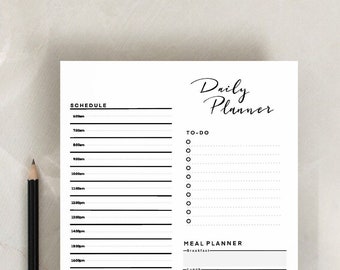 May include: A black and white daily planner with sections for schedule, to-do list, meal planner, and notes. The planner has a simple design with black lines and text.