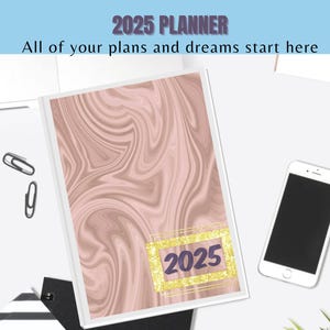 Op de afbeelding: Een 2025-planner met een roze en bruin marmerontwerp. De omslag heeft een gouden frame met het jaar 2025 in paarse tekst.