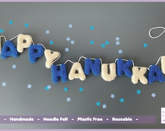 May include: A felt banner with the words "Happy Hanukkah" in blue and white letters. The banner is strung with white thread and is surrounded by blue and white stars.