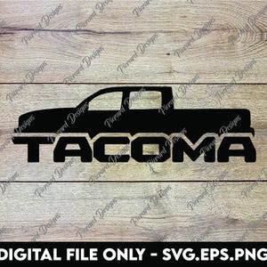 May include: Black and white silhouette of a pickup truck with the word "TACOMA" printed below it. The image is on a woodgrain background.