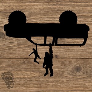 May include: A black silhouette decal featuring an overturned vehicle with two figures hanging from the underside. One figure is a person and the other is a large creature, accompanied by a small footprint icon in the bottom left corner.