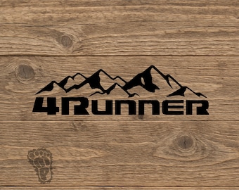 May include: A black vinyl decal featuring a stylized mountain range silhouette positioned above the text 4RUNNER in a bold, blocky font. A small, faint footprint icon is located in the lower left corner of the design.