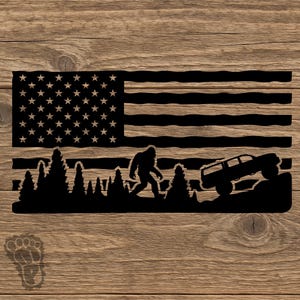 May include: A black metal wall art piece featuring a silhouette of the American flag with stars and stripes. The design incorporates a forest of pine trees, a walking Bigfoot figure, and an off-road vehicle climbing a rocky incline.