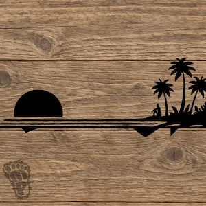 May include: Black silhouette of a sunset over the ocean with palm trees and a person sitting on the shore. The design is on a wooden background. The image has a tropical theme.