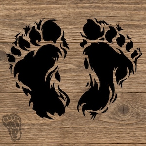 May include: A black graphic decal featuring two stylized footprints with flame-like edges, resembling a mythical creature's tracks. A smaller, faint, semi-transparent footprint icon is positioned in the bottom left corner of the design.