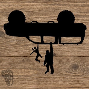 May include: Black silhouette of a vehicle overturned, with a woman and Bigfoot hanging from it. The image is set against a wood grain background, with a Bigfoot footprint in the lower left corner. A fun, outdoor-themed design.