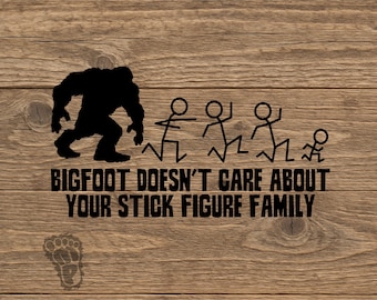May include: A black vinyl decal featuring a silhouette of Bigfoot chasing a stick figure family. The text reads BIGFOOT DOESN'T CARE ABOUT YOUR STICK FIGURE FAMILY. A small footprint icon is positioned below the text on a wood grain surface.