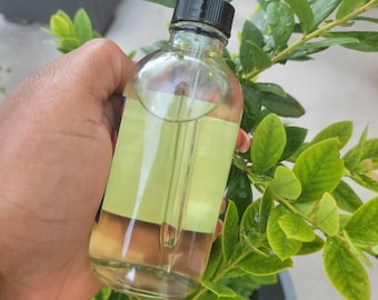 May include: A clear glass bottle with a black dropper top filled with a light yellow liquid. The bottle has a light green label with a white border.