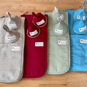 May include: Four pot holders with matching pot holders in different colors: gray, red, green, and blue. Each pot holder has a pocket for a pot holder and a label that says "Handmade with love by Mitsuko".