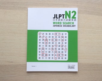 Könnte beinhalten: Ein grünes und weißes Buch mit dem Titel "JLPT N2 Japanese Ability Test Vocabulary Word Search" und dem Text "The East Interpreter" in der unteren rechten Ecke. Der Buchumschlag zeigt ein Wortsuchrätsel mit japanischen Schriftzeichen.