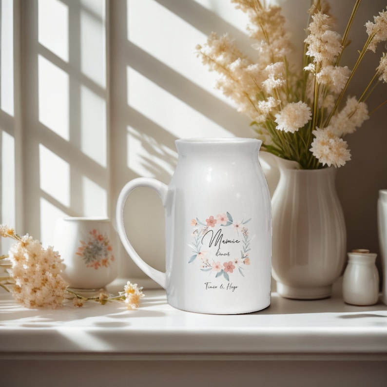 May include: White ceramic pitcher with a floral design and the text "Mamie loves" and "Timo & Hugo".
