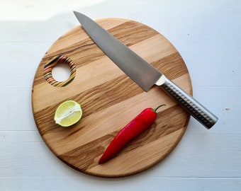 Round chopping board made from recycled skateboards.