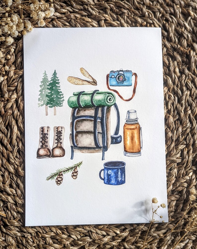 Op de afbeelding: Een aquarel-illustratie van kampeeruitrusting, waaronder een groen-bruine rugzak, een blauwe thermosfles, een blauwe mok met een maan- en boomontwerp, een paar bruine wandelschoenen, een blauwe camera en een groene slaapzak.