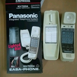 May include: A white Panasonic KX-T2204 EASA-PHONE integrated telephone system with a lighted dial. The phone has a 15-station automatic dialer and features a speakerphone, flash, redial, pause, hold, and mute buttons.