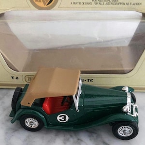 Op de afbeelding: Een groene vintage speelgoedauto met een beige cabriokap en rood interieur. De auto heeft nummer 3 op de deur en zilveren wielen. De doos leest "models of yesteryear" en "for ages 8 and over".