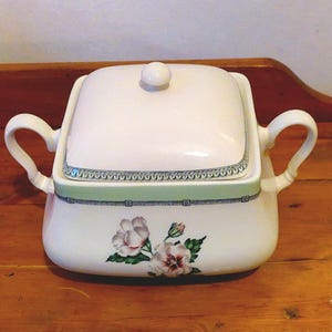 Pode incluir: Prato de servir quadrado de porcelana branca com tampa e duas alças. O prato tem um design floral verde e branco com uma borda verde.