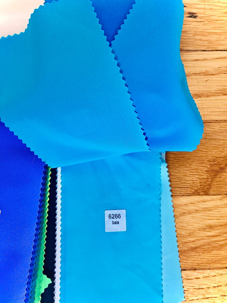 May include: A stack of fabric swatches in various shades of blue, with a white label that reads "6266 bala".