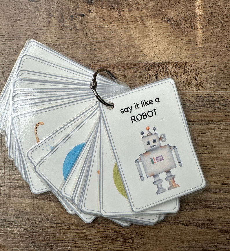 K&ouml;nnte beinhalten: Ein Satz von Karteikarten mit einer Roboterillustration auf der Vorderseite. Der Text auf der Vorderseite lautet "say it like a ROBOT".