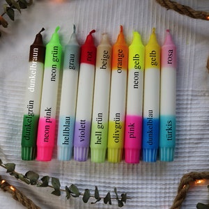 May include: Ten candles with two-toned colors. The candles are white with a colored bottom half. The colors are dark green, neon pink, neon green, light blue, gray, violet, red, light green, beige, olive green, orange, pink, neon yellow, dark blue, yellow, turquoise, and pink.