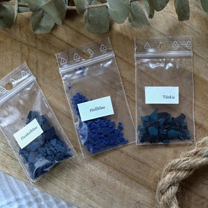 May include: Three small bags of blue wax flakes labeled "Dunkelblau", "Hellblau", and "T&uuml;rkis".
