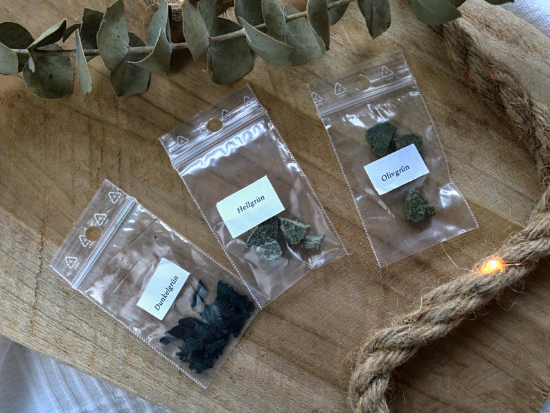 May include: Three small plastic bags containing green and black rock chips. The bags are labeled "Dunkelgr&uuml;n", "Hellgr&uuml;n", and "Oligr&uuml;n".