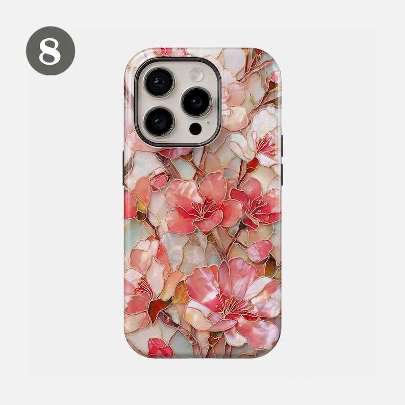May include: A phone case featuring a floral design with pink and white blossoms. The case has a glossy finish and a raised design, with a light background. The case has a camera cutout and buttons.