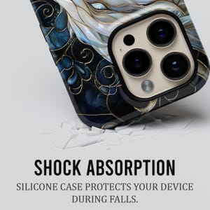 May include: A smartphone case featuring a dark blue and white marbled pattern with gold-coloured filigree lines. The text SHOCK ABSORPTION and SILICONE CASE PROTECTS YOUR DEVICE DURING FALLS is printed below the case on a plain light background.