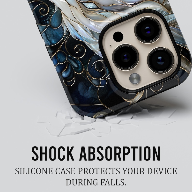 May include: A smartphone case featuring a dark blue and white marbled pattern with gold-coloured filigree lines. The text SHOCK ABSORPTION and SILICONE CASE PROTECTS YOUR DEVICE DURING FALLS is printed below the case on a plain light background.