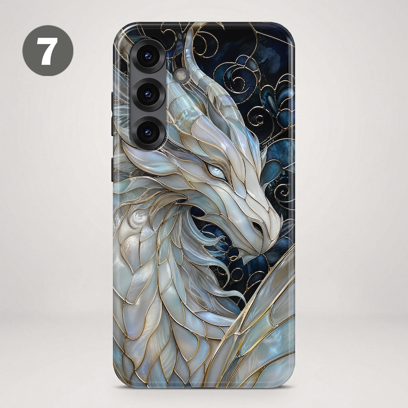 May include: A smartphone case featuring a white dragon with iridescent, scale-like segments outlined in gold. The background is a dark blue with gold filigree patterns. The design covers the entire back of the phone, including the camera area.