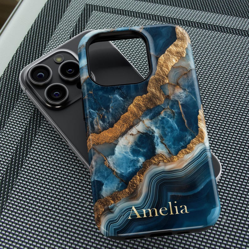 May include: A blue and gold marble phone case with the name Amelia printed on the bottom.