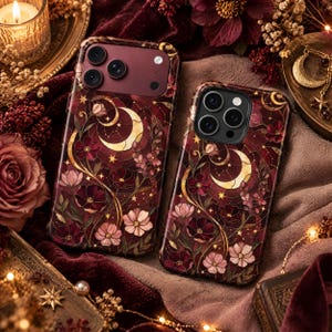 May include: Two smartphone cases featuring a dark red and burgundy stained-glass style design with gold crescent moons, stars, and floral patterns. The cases have a multi-lens camera cutout and a smooth, glossy finish with intricate line work.