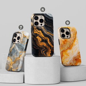 May include: Three iPhone cases with different marble patterns. The cases are black, gray, and white with gold accents. The cases are all made of a hard plastic material.
