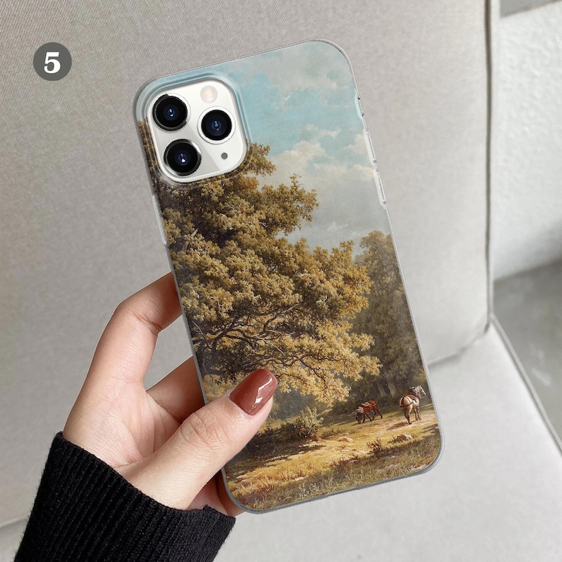 Peut inclure: Une coque de t&eacute;l&eacute;phone transparente avec un paysage peint d'une sc&egrave;ne de for&ecirc;t. La peinture repr&eacute;sente un grand arbre aux feuilles vertes, un ciel bleu avec des nuages blancs et un chemin qui traverse la for&ecirc;t. On peut &eacute;galement voir deux chevaux au loin.
