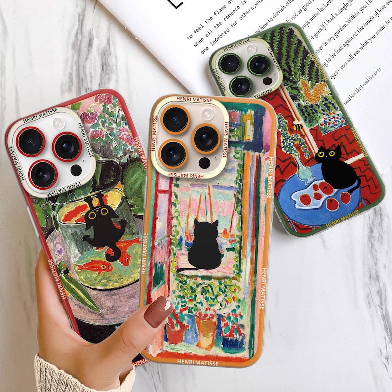 K&ouml;nnte beinhalten: Drei farbenfrohe Handyh&uuml;llen mit Kunstwerken von Henri Matisse. Jede H&uuml;lle hat ein anderes Design mit einer schwarzen Katze, einer Fischschale und einem Fenster mit Blumen. Die H&uuml;llen sind aus strapazierf&auml;higem Kunststoff und haben eine transparente R&uuml;ckseite, um die Kunstwerke zu pr&auml;sentieren.