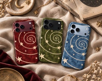 May include: Three smartphone cases in deep red, olive green, and slate blue, each featuring a gold-toned spiral pattern with scattered stars. The cases have a smooth finish and a rectangular camera cutout at the top, showcasing a celestial design.