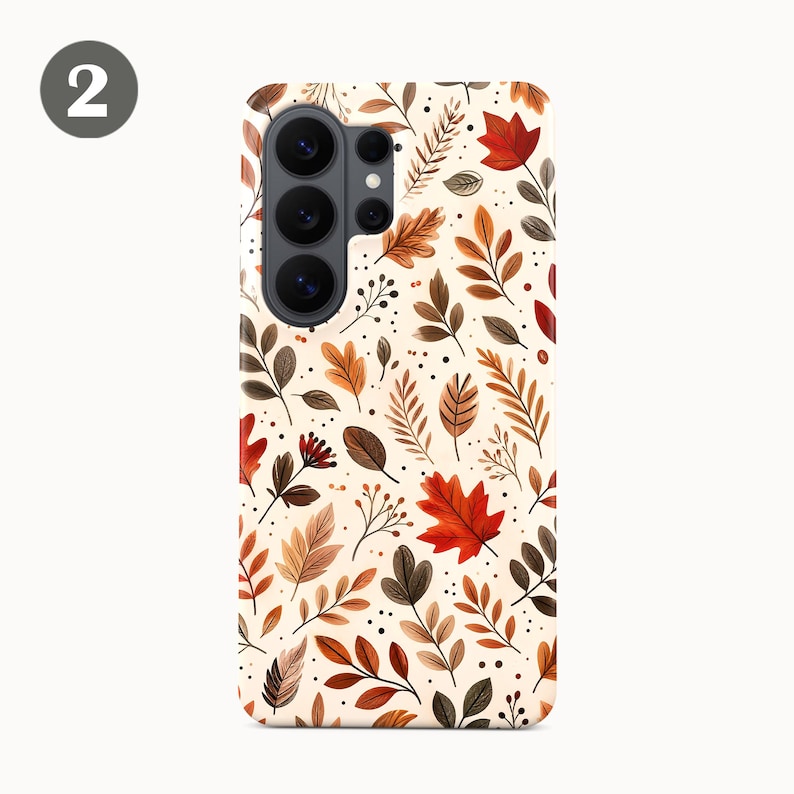 Puede incluir: Una funda rectangular para smartphone con fondo color crema y un patr&oacute;n repetitivo de hojas de oto&ntilde;o en tonos rojo, naranja y marr&oacute;n, acentuado con peque&ntilde;os puntos negros y tallos finos, con un m&oacute;dulo de c&aacute;mara negro en la parte superior.