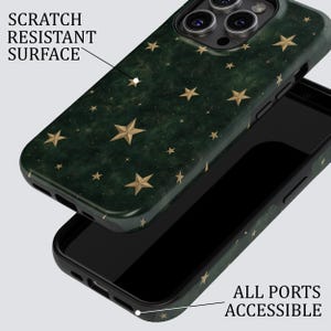 May include: A dark green smartphone case featuring a pattern of gold stars. The case has a scratch resistant surface and is designed with cutouts to ensure all ports are accessible. The camera lens area is visible at the top of the phone case.