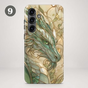 May include: A smartphone case featuring a stained glass style illustration of a green dragon with gold outlines. The dragon has detailed scales and a sharp green eye. The background consists of cream and gold swirling patterns.