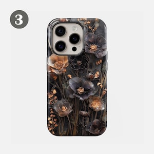 May include: A phone case featuring a dark floral design with black, gold, and brown flowers. The case has a glossy finish and a camera cutout. The flowers are detailed and layered, creating a 3D effect. The overall aesthetic is elegant and nature-inspired.