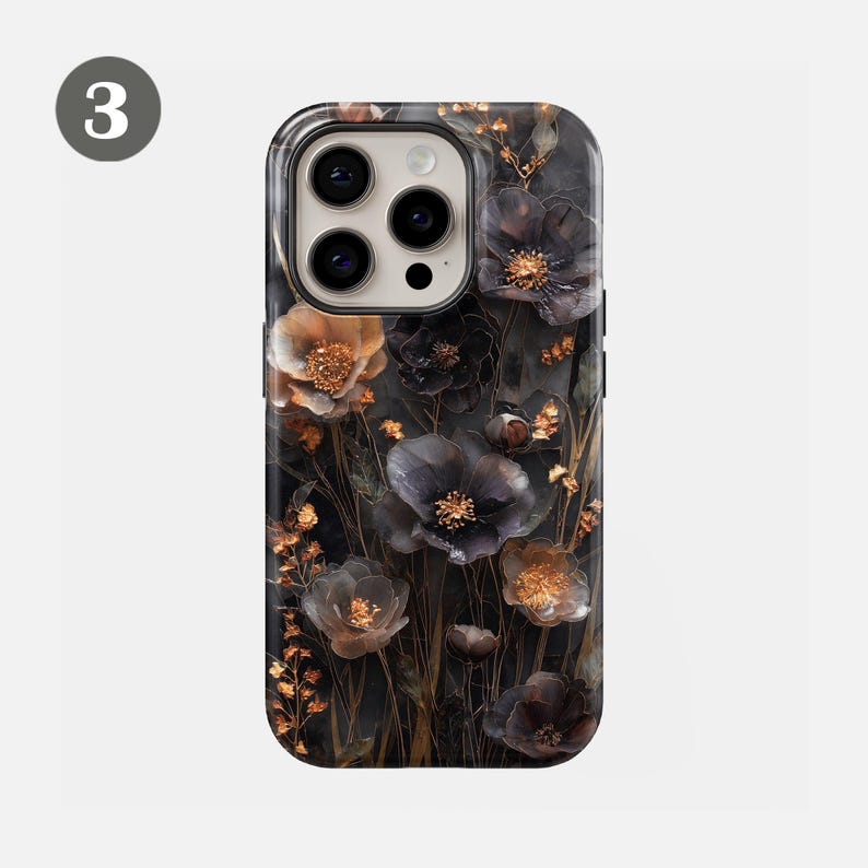 May include: A phone case featuring a dark floral design with black, gold, and brown flowers. The case has a glossy finish and a camera cutout. The flowers are detailed and layered, creating a 3D effect. The overall aesthetic is elegant and nature-inspired.